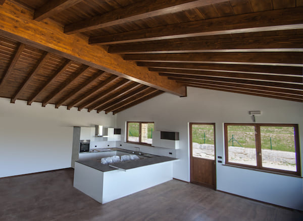 Villa legno gignese, vista degli interni, cucina open space e copertura in legno con travi a vista